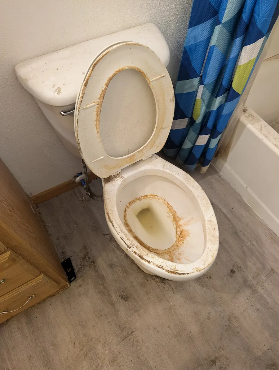 Heavily stained toilet bowl with years of dirt and buildup before deep cleaning in Fargo, ND